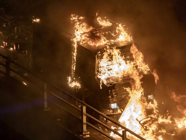 A police personnel vehicle is on fire as protesters and police clash on a bridge at The Hong Kong Poytechnic University. Picture: Anthony Kwan/Getty Images