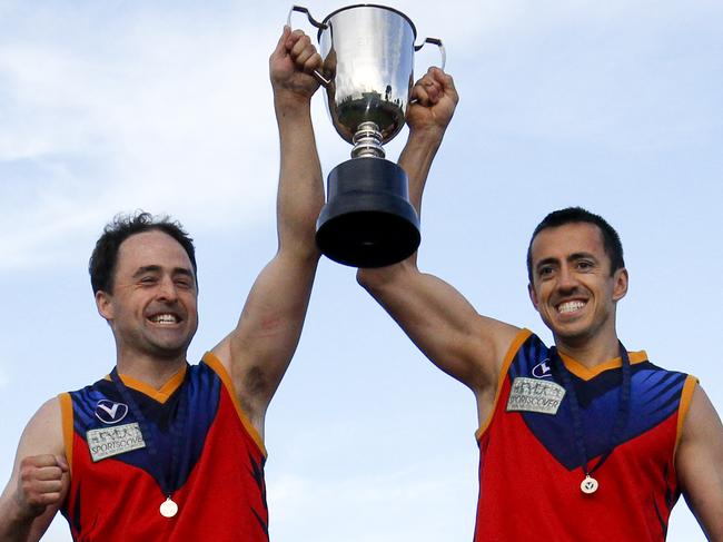 Captain Paul Sullivan and playing coach Sam Radford lift the grand final trophy with Parkdale in 2011.