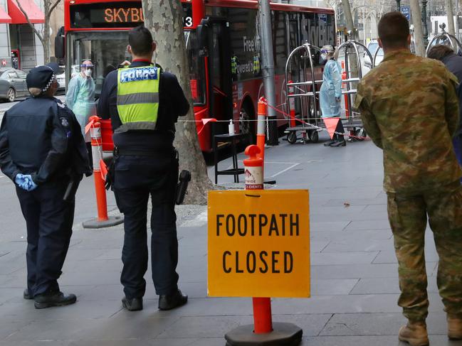 Police and Army personnel monitor international arrivals. David Crosling