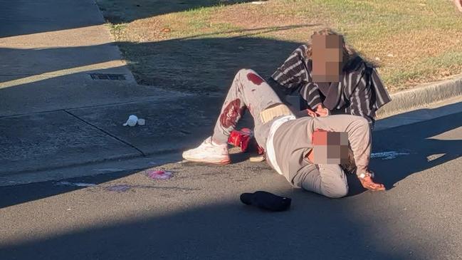 01/06/2025 Dramatic images show the scene in the aftermath of a shooting in Melton on Sunday morning. , The victim, in tracksuit pants and a t-shirt, appeared to have suffered a leg wound., He was comforted by another man as locals waited for emergency services to arrive. picture: Outlaw Media,