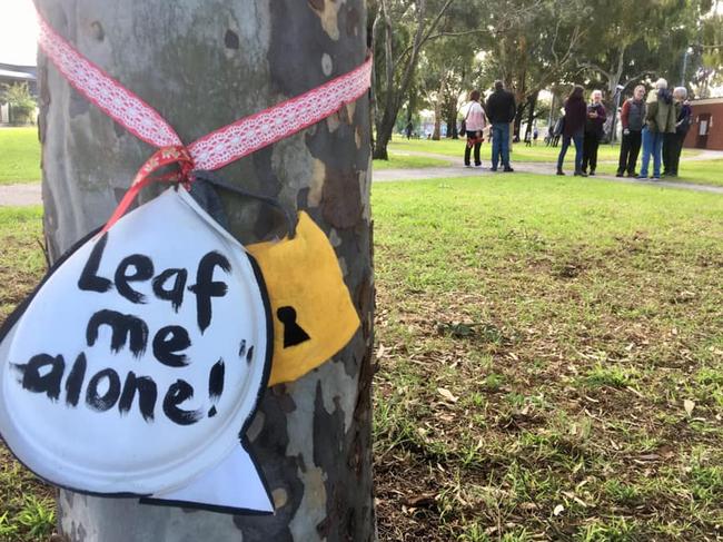 A sign wrapped around a tree in Gandolfo Gardens.