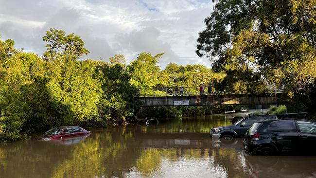 Flash flooding after heavy rain on the Sunshine Coast saw Petrie Creek burst its banks, leaving cars in a carpark near Nambour Plaza submerged. Photo: Mark Furler