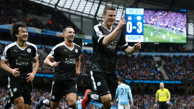 Leicester City's German defender Robert Huth (R) celebrates scoring his team's third goal with Leicester City's Japanese striker Shinji Okazaki (L) and Leicester City's Algerian midfielder Riyad Mahrez during the English Premier League football match between Manchester City and Leicester City at the Etihad Stadium in Manchester, north west England, on February 6, 2016. / AFP / ADRIAN DENNIS / RESTRICTED TO EDITORIAL USE. No use with unauthorized audio, video, data, fixture lists, club/league logos or 'live' services. Online in-match use limited to 75 images, no video emulation. No use in betting, games or single club/league/player publications. /