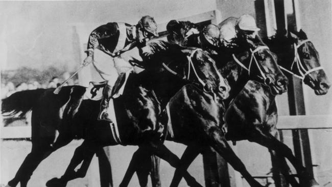 Ark Royal ridden by jockey Reg Heather, Pandie Sun ridden by Bill Williamson and Fighting Force ridden by Jack Purtell cross the finish line in a dead heat in the 1956 Hotham Handicap.
