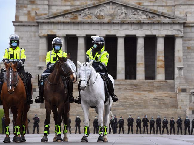 Police stand guard in front of the Shrine of Remembrance during an anti-lockdown rally in Melbourne on September 12, 2020, as the city continues to enforce strict lockdown measure to battle a second wave of COVID-19 coronavirus infections. (Photo by William WEST / AFP)