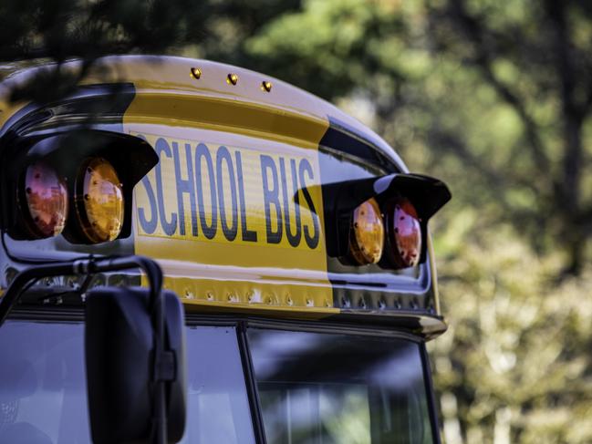 Yellow school bus for kids shot close up at the front text and windshield, istock