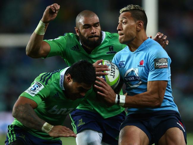 Israel Folau tries to push away two Highlanders defenders in the Waratahs’ convincing victory.