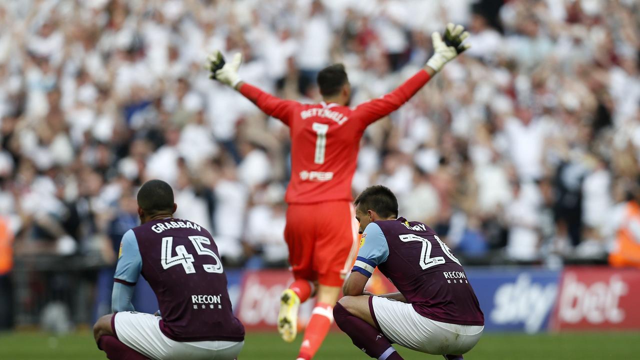 Fulham's English goalkeeper Marcus Bettinelli celebrates as Aston Villa's English striker Lewis Grabban (L0 and Aston Villa's English defender John Terry (R) react