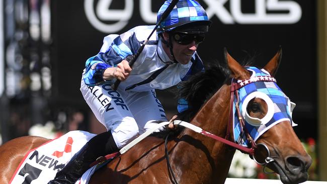 Jockey John Allen raises his whip after his victory on Kenedna. Picture: AAP