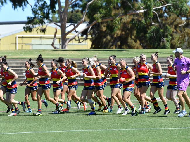 Crows players run onto the field during the Round 6 AFLW match between the Crows and GWS Giants at Richmond Oval on March 15, 2020, with no spectators allowed. Picture: AAP IMAGE/DAVID MARIUZ