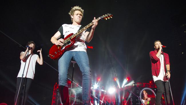 Earlier that night ... Louis Tomlinson, Niall Horan (centre), and Liam Payne on stage at Melbourne’s Etihad Stadium on Saturday. Picture: Eugene Hyland