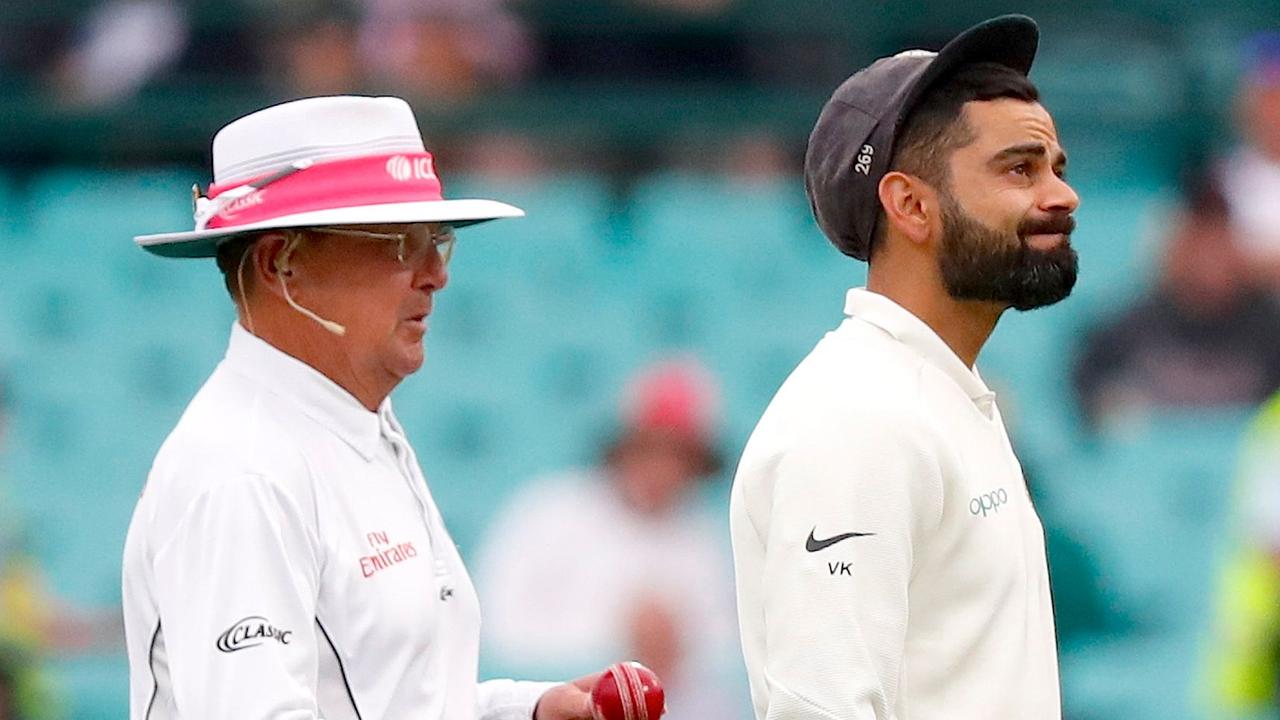 India's captain Virat Kohli reacts as he walks off the ground with umpire Ian Gould.