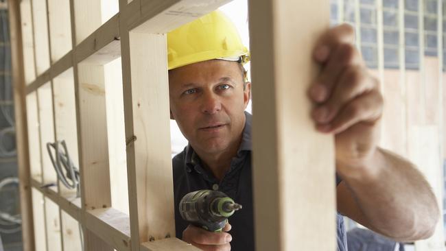 Construction worker building timber frame in new home.