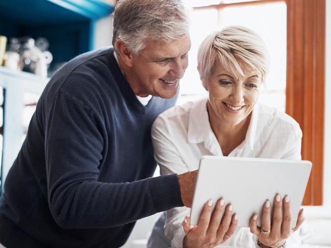 Shot of a mature couple having coffee while using their digital tablet at home