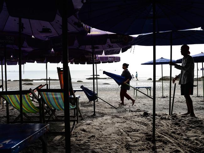 Workers assemble umbrellas on the beach at the upscale resort town of Hua Hin where bombs exploded. Picture: AFP