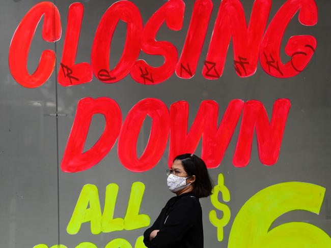 A woman walks past a closing down sign on an empty shop in Melbourne's central business district on June 3, 2020. - Australia is heading for its first recession in nearly three decades after the economy shrunk in the January-March quarter, with a "far more severe" reading expected in the next three months as the effects of the virus shutdown bite. (Photo by William WEST / AFP)