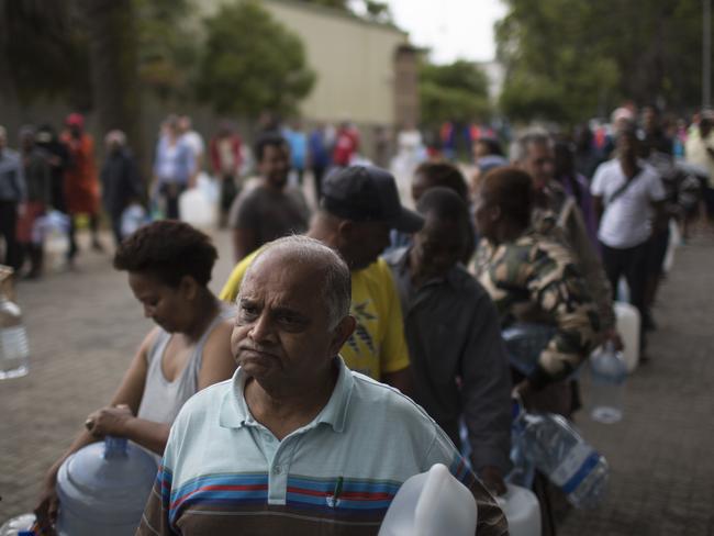 On February 2, residents wait in a queue to fill containers with water at a source for natural spring water in Cape Town. Picture: Bram Janssen