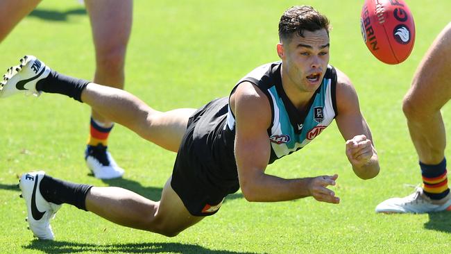 Karl Amon of Port Adelaide dishes off a flying handball against the Crows.