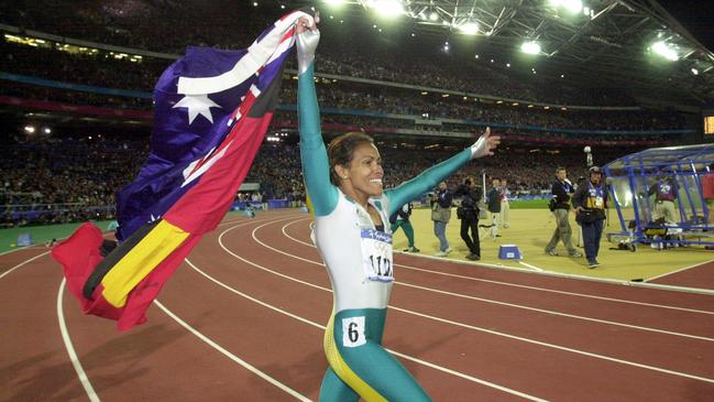 Cathy Freeman walking a lap of honour, carrying the Australian and Aboriginal Flags, after winning Gold in the Womens 400m Finals at the Sydney Olympic Games. (AAP PHOTO/Dean Lewin)