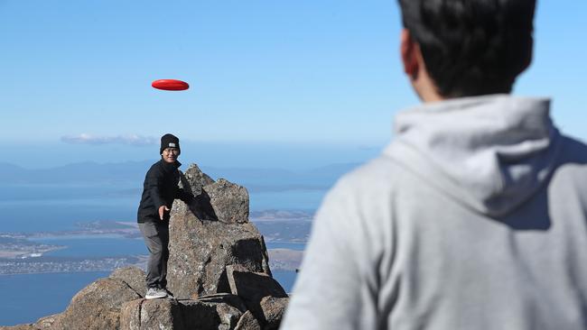 UTAS international student Chris Guo throwing a frisbee on the summit of Mount Wellington with friend and fellow student E Kong (back to camera). Picture: LUKE BOWDEN