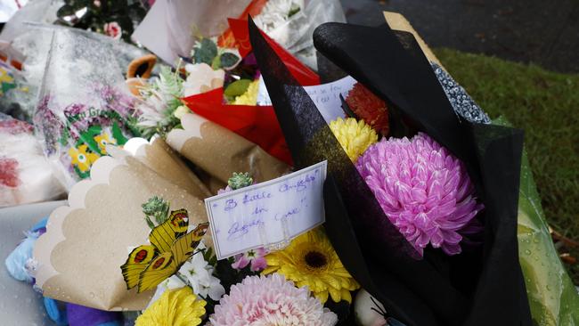 Flowers laid across the road in Lalor Park in Sydney, where three children died. Picture: Richard Dobson