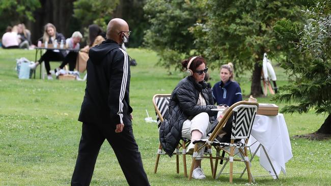 A woman is seen dining at a Melbourne park as eateries remain closed.