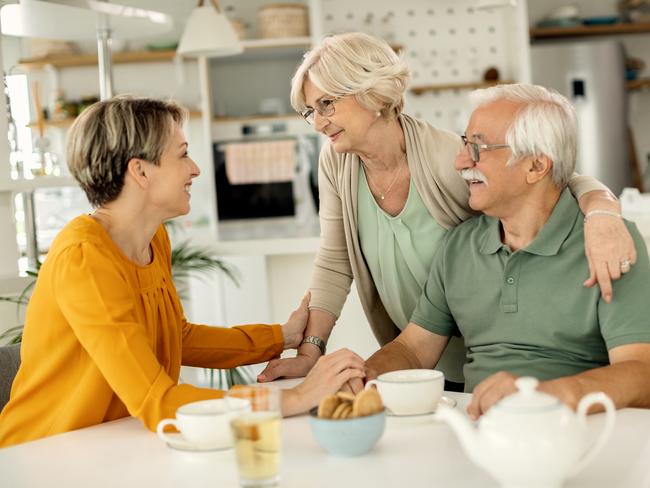 Happy woman visiting her senior parents and communicating with them at home. Family generic  Baby Boomers