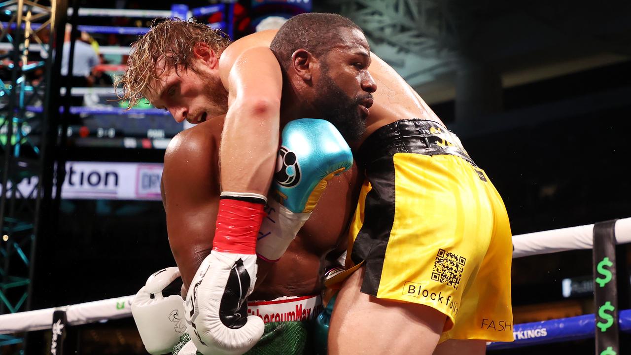 MIAMI GARDENS, FLORIDA - JUNE 06: Floyd Mayweather (green shorts) exchanges blows with Logan Paul during their contracted exhibition boxing match at Hard Rock Stadium on June 06, 2021 in Miami Gardens, Florida. (Photo by Cliff Hawkins/Getty Images)