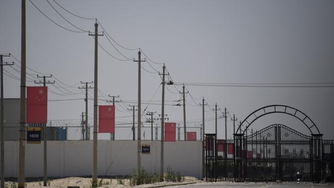 Chinese flags are seen on a road leading to a facility believed to be a re-education camp where mostly Muslim ethnic minorities are detained, on the outskirts of Hotan in China's northwestern Xinjiang region. Picture: Greg Baker/AFP