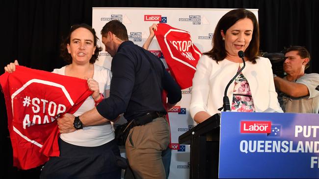 A protester is led away after ambushing Queensland Premier Annastacia Palaszczuk on her first day of campaigning for the November 25 election. Picture: AAP