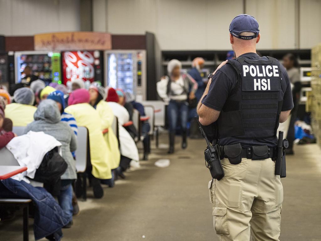 A Homeland Security Investigations (HSI) officer guards suspected illegal aliens on August 7, 2019. Picture: AFP