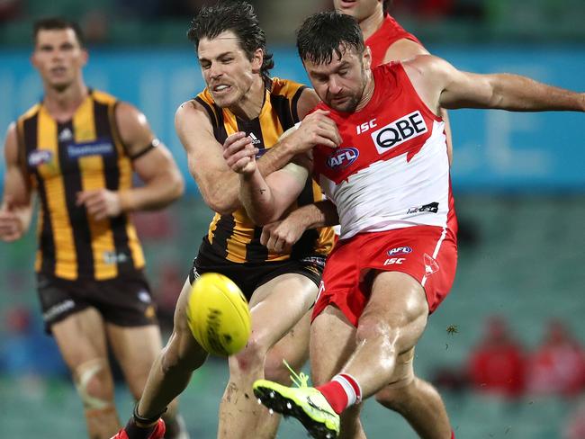 SYDNEY, AUSTRALIA - JULY 25: Sam Gray of the Swans kicks whilst being tackled by Isaac Smith of the Hawks during the round 8 AFL match between the Sydney Swans and the Hawthorn Hawks at the Sydney Cricket Ground on July 25, 2020 in Sydney, Australia. (Photo by Cameron Spencer/Getty Images)