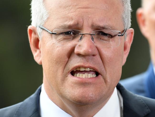 Australian Prime Minister Scott Morrison (left), watched by Minister for Home Affairs Peter Dutton, speaks during a press conference in Brisbane, Friday, December 14, 2018. (AAP Image/Dan Peled) NO ARCHIVING