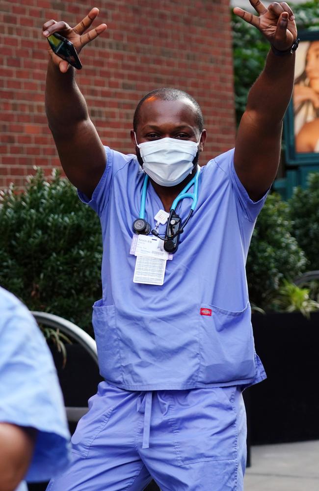 A medical worker outside New York’s Lenox Hill Hospital as locals cheer to show gratitude to frontline workers during the coronavirus pandemic. Picture: Getty Images