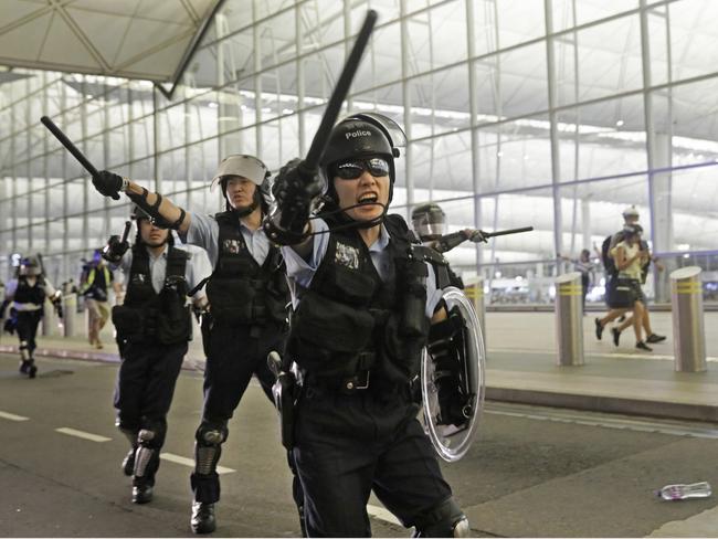 Policemen with batons and shields shout at protesters during a demonstration at the Airport in Hong Kong this week. Picture: Getty