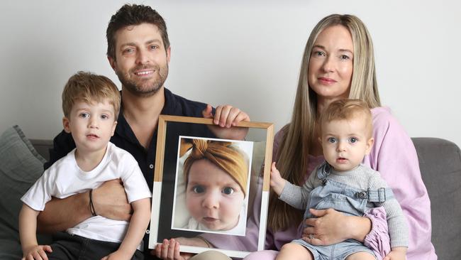 Jonathan and Rachael Casella with sons Izaac, 2, and Joshua 10 months, and a picture of baby Mackenzie. Picture: John Feder