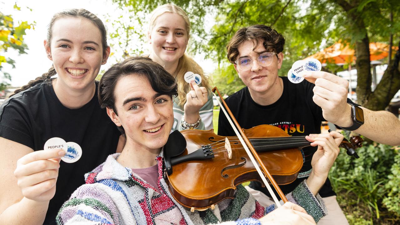A Mate's Banjo member Joe Watson gets support from friends (back, from left) Amelia Condon, Kaylee Keehn and Riley Furse in the Toowoomba Busking Festival, Saturday, April 30, 2022. Picture: Kevin Farmer