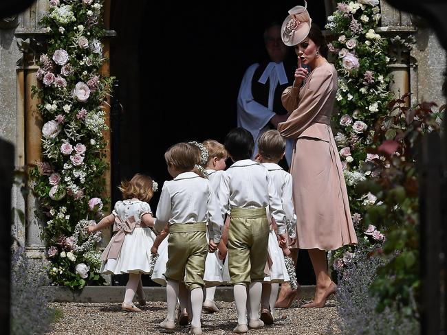 The Duchess of Cambridge gestures to the children as she assembles the bridesmaids and pageboys.