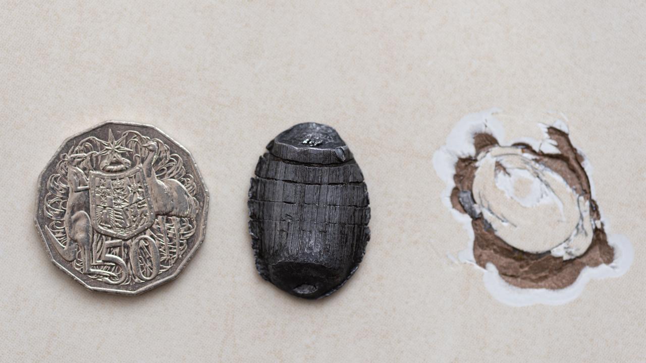 The unidentified flying object, with a 50 cent piece for scale, next to the chip on the Gympie couple’s tiled floor. Picture: Paul Beutel