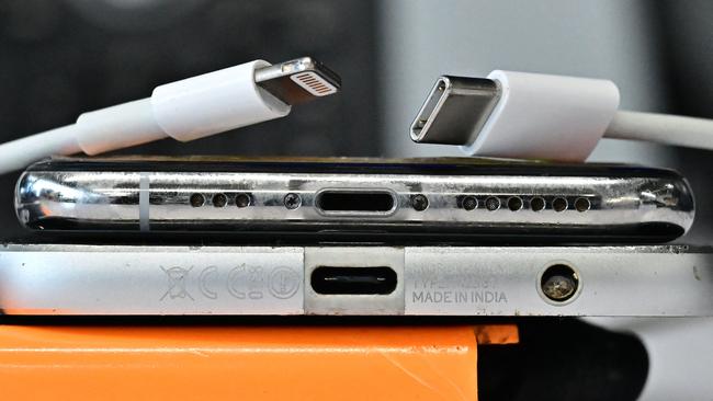 A USB-C charger (R) and a traditional Apple Lightning charger (L) are seen on an Apple iPhone with Lightning port above an Android phone with a USB-C port on September 11, 2023 in Los Angeles. The new Apple iPhone 15, with an EU ordered USB-C charger, is expected to be announced during a launch event on September 12, 2023. (Photo by Frederic J. BROWN / AFP)