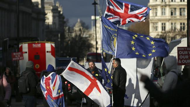 Anti-Brexit protesters wave flags outside the Houses of Parliament ahead of the leadership vote. Picture: AP.