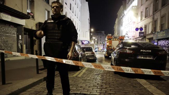 A policeman stands behind a cordon blocking the street near the site of an attack in a restaurant in Paris. AFP PHOTO