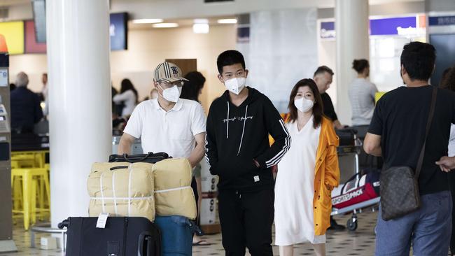 People arriving from Asian countries wearing masks at Brisbane International Airport, 29th of January 2020. *none of the people pictured carry coronavirus (AAP Image/Attila Csaszar)