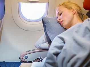 Lady traveling napping on a plain.