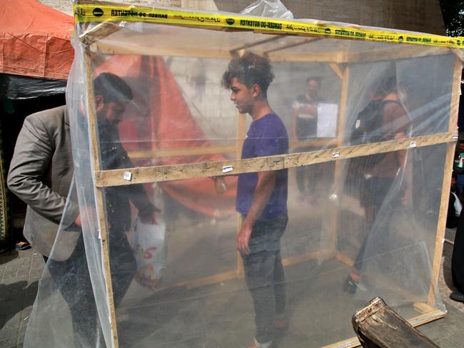 Protesters being disinfected in a makeshift disinfection booth. Picture: Khalid Mohammed