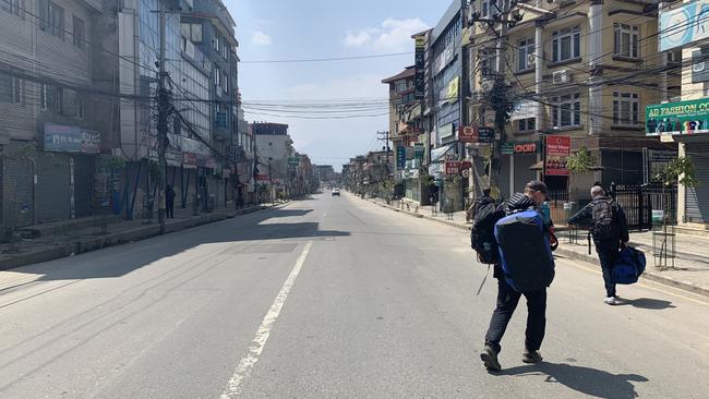 Empty streets outside the Australian Embassy as Australians Paul Ashenden, Tony Symons and Ryan Cox walk to a find a hotel. Picture: Brad Fleet