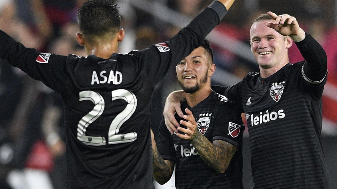 D.C. United midfielder Luciano Acosta (centre) celebrates his winning goal with forward Wayne Rooney (right) and Yamil Asad (left) on Monday. Picture: AP