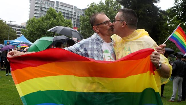 Same sex marriage supporters, including Ian Brett and Michael Collins, hear the result in Adelaide’s Hindmarsh Square. (Pic: Kelly Barnes/The Australian)