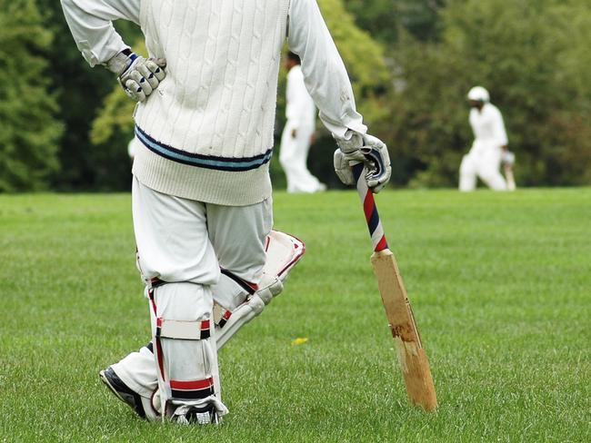 Cricket player waiting, leaning on the bat.  - Picture istock