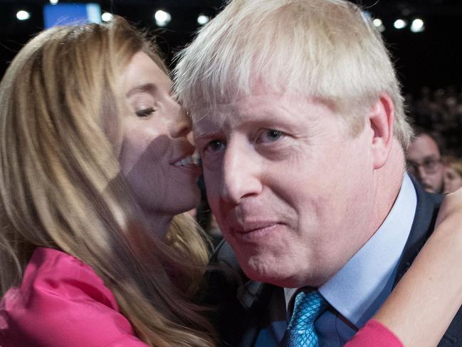 (FILES) In this file photo taken on October 02, 2019 Britain's Prime Minister Boris Johnson (R) is embraced by his partner Carrie Symonds as they leave after he  delivered his keynote speech to delegates on the final day of the annual Conservative Party conference at the Manchester Central convention complex, in Manchester, north-west England - Britain's Prime Minister Boris Johnson appeared to be on the road to recovery as Downing Street said the Prime Minister had returned to the ward at St Thomas' Hospital after spending three nights in the intensive care unit. (Photo by Stefan Rousseau / POOL / AFP)